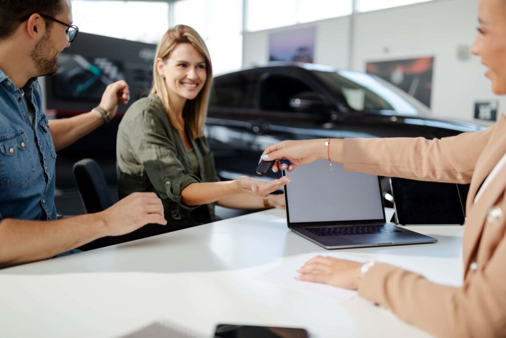  person receiving the keys for a new car they have bought