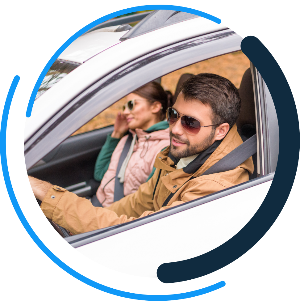 couple driving inside of the one day insurance logo