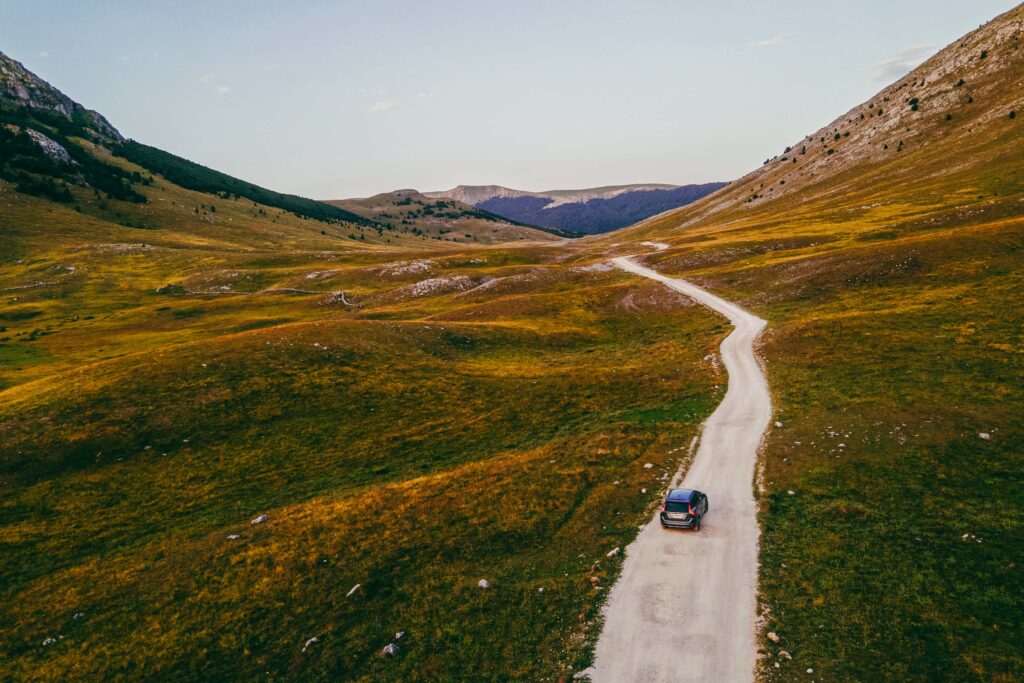 people driving though the Scottish highlands