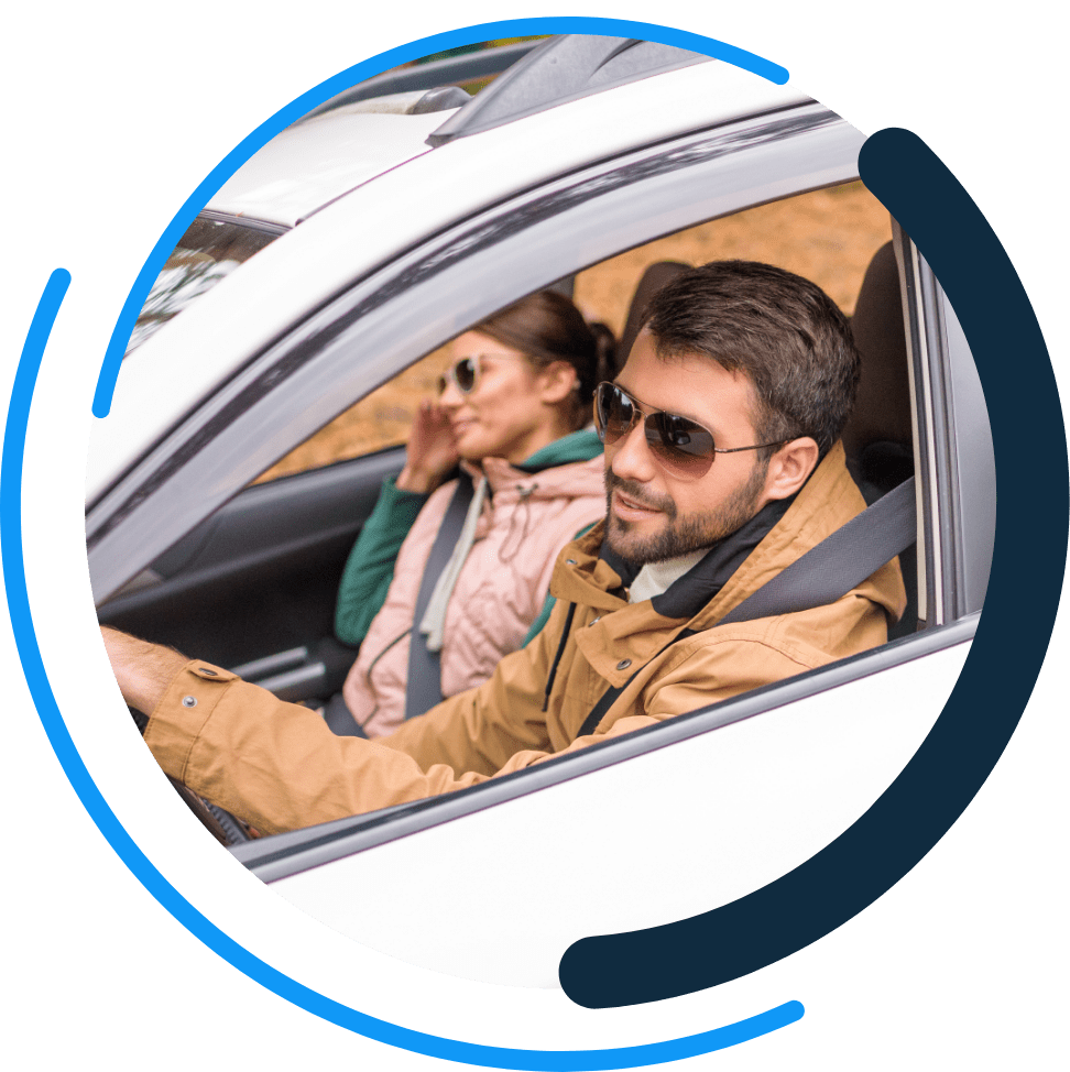 couple driving inside of the one day insurance logo