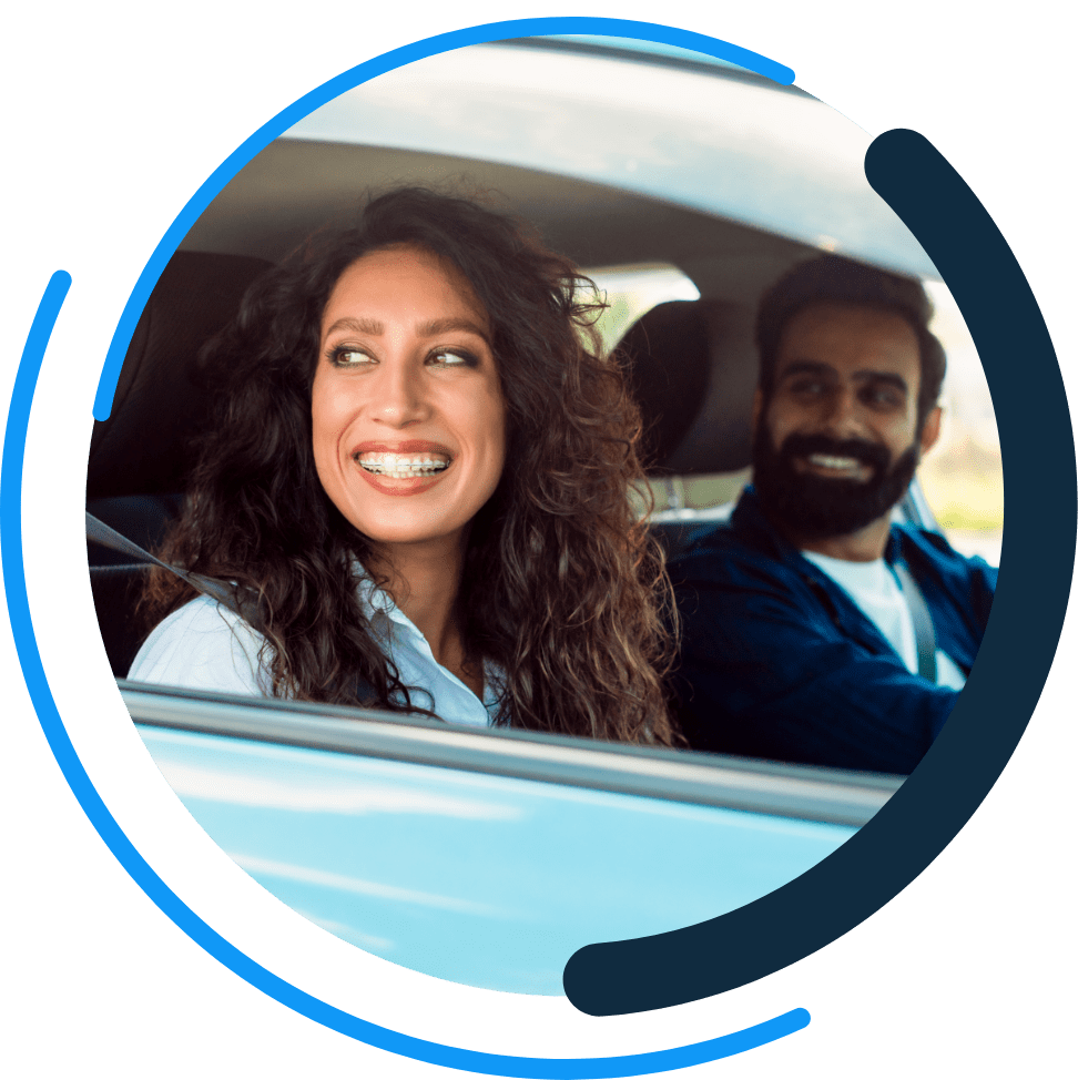 couple inside of the one day insurance logo driving a car